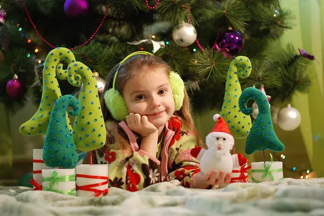 Petite fille sous un sapin de Noël à la veille de l'année 2024.