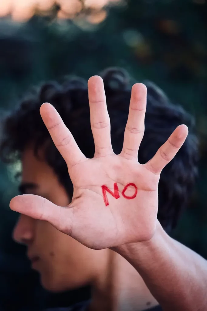 Personne qui tend sa main pour mettre de la distance avec quelqu'un. Cela peut-être vécu comme une blessure de rejet.
