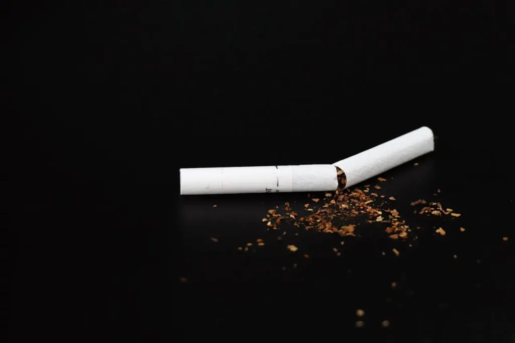 Cigarette neuve brisé en deux avec du tabac répandu sur la table.