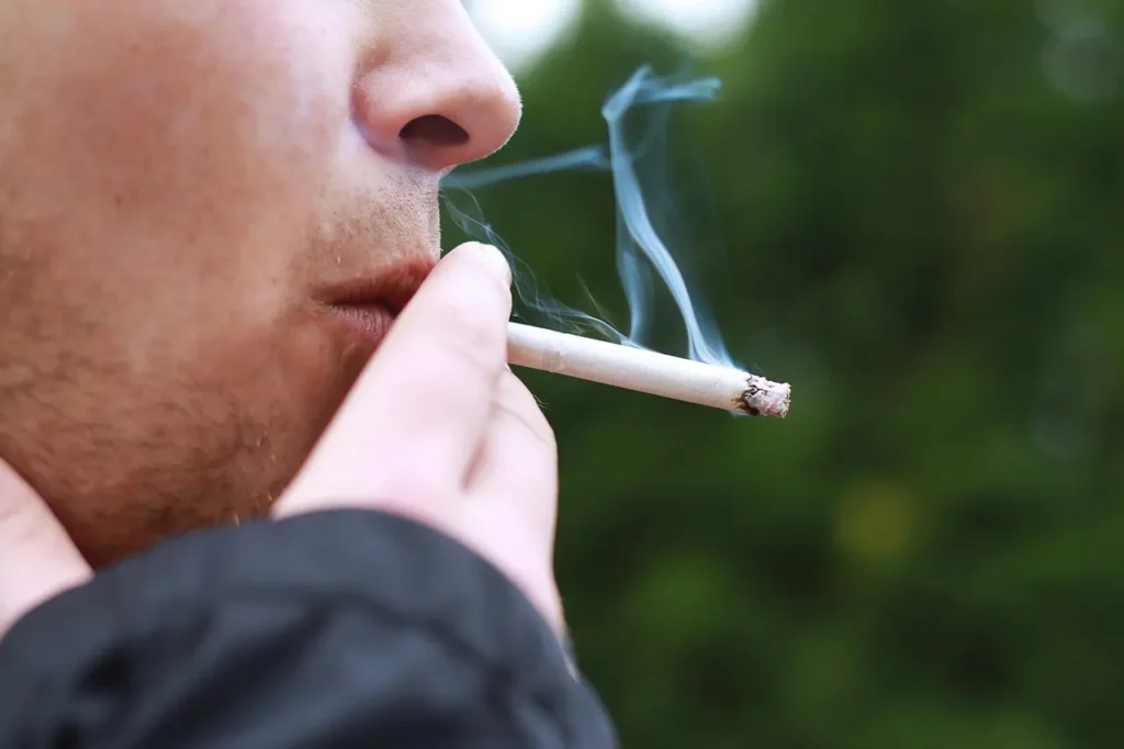 Personne qui fume une cigarette.