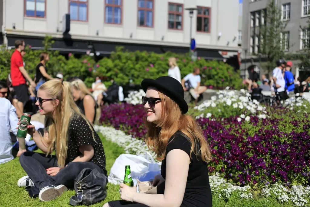 Deux jeunes filles une canette de bière à la main lors d'un rassemblement extérieur.