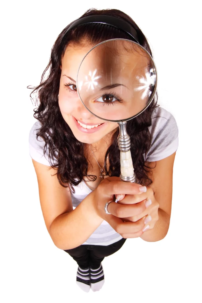 Cette image représente une jeune femme avec une loupe qui illustre comment choisir son hypnothérapeute : 7 critères clés.